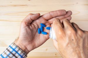 Top view pov of adult man taking blue pills selective focus